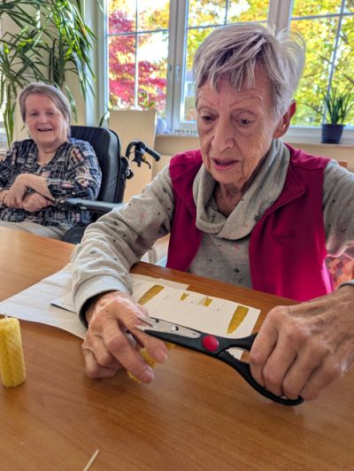 Bewohnerin bastelt Kerze mit Bienenwachs